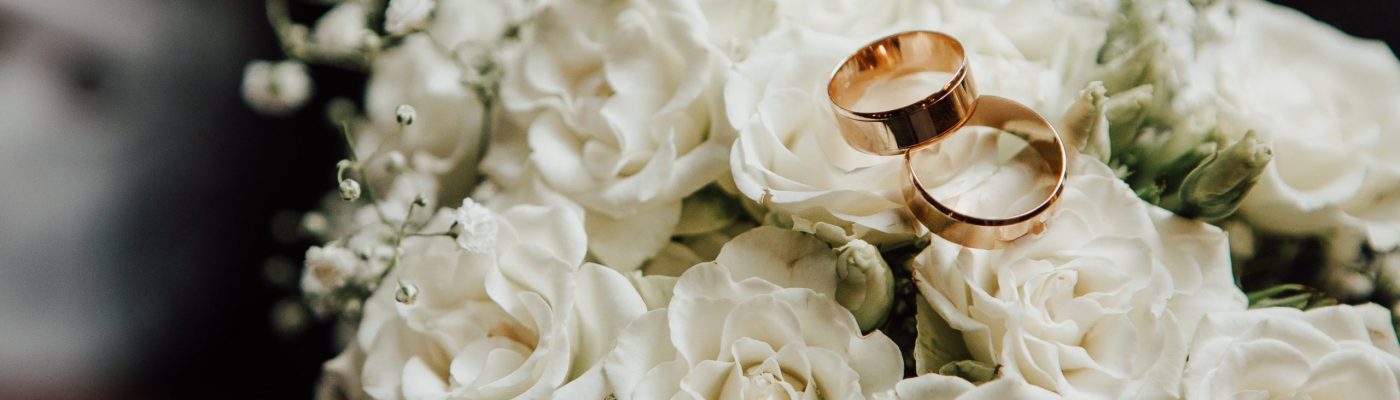Wedding,Rings,On,The,Wedding,Bouquet,Of,White,Roses. Wedding,Rings,On,The,Wedding,Bouquet,Of,White,Roses.